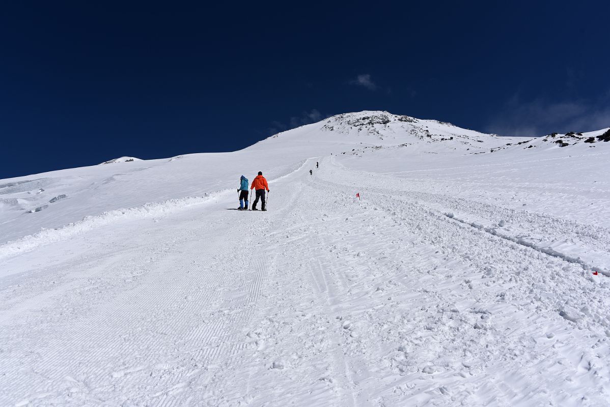 08A Zig Zagging To Climb Steep Trail To Pastukhov Rocks With Mount Elbrus West And East Summits Above